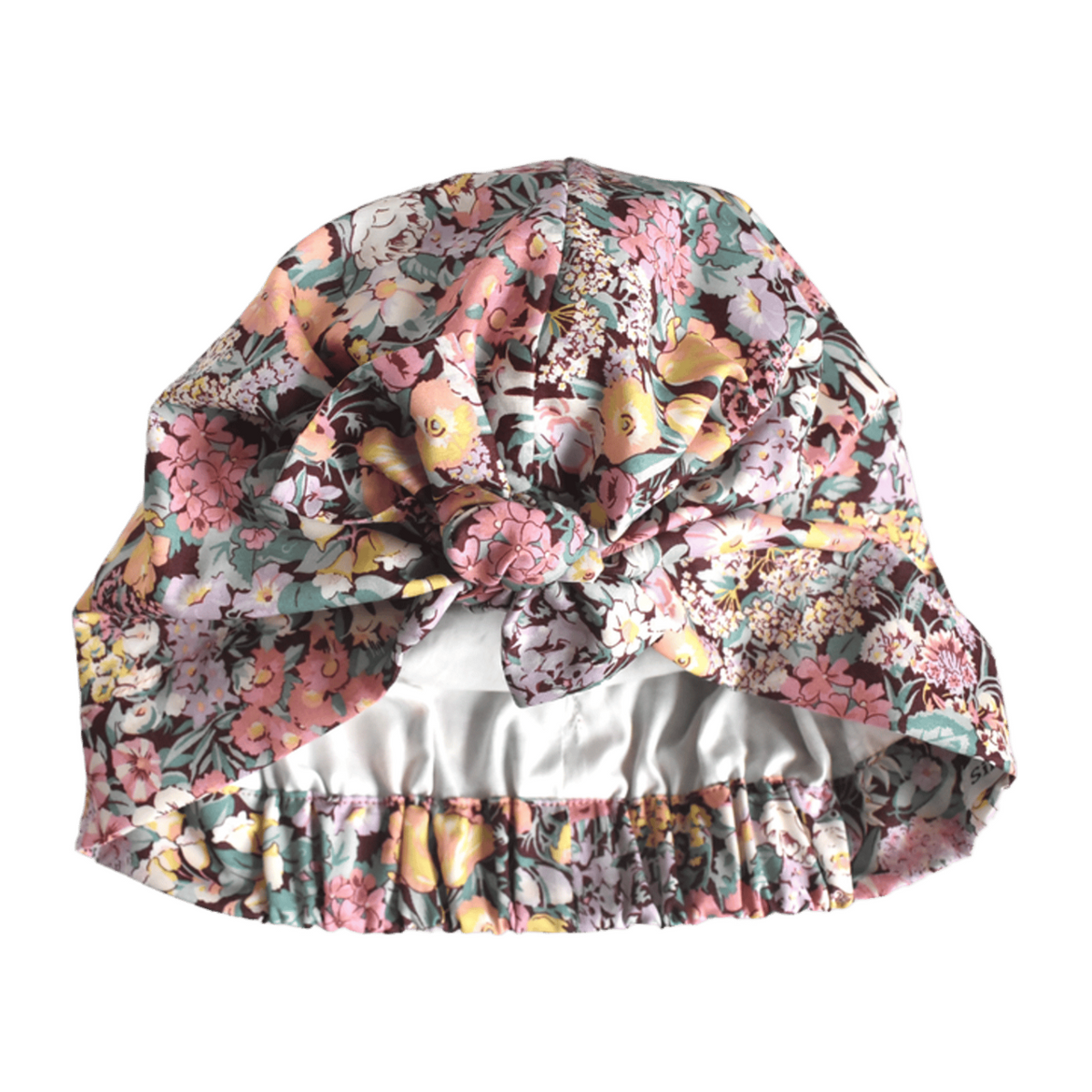 Liberty Cottage Garden floral print turban or sleep bonnet with a large bow on top and a elasticated back, shown against a plain white background.