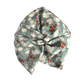 A knotted fabric headwrap or hair tie in a sage green wool Liberty  fabric headwrap or turban in a muted sage green color, featuring a white floral and red berry pattern, Vintage Liberty Winter Berries in Aqua Blue   - Varuna Wool 