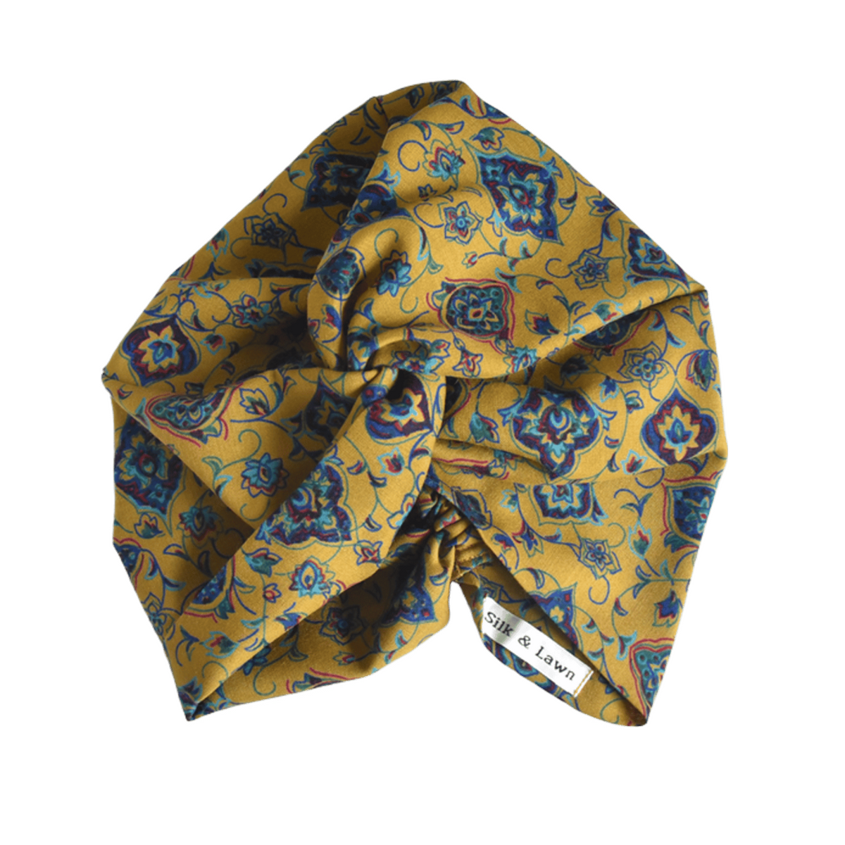  A mustard yellow fabric twisted headwrap or turban with a blue floral and geometric pattern, in varuna wool from hair accessory brand Silk & Lawn