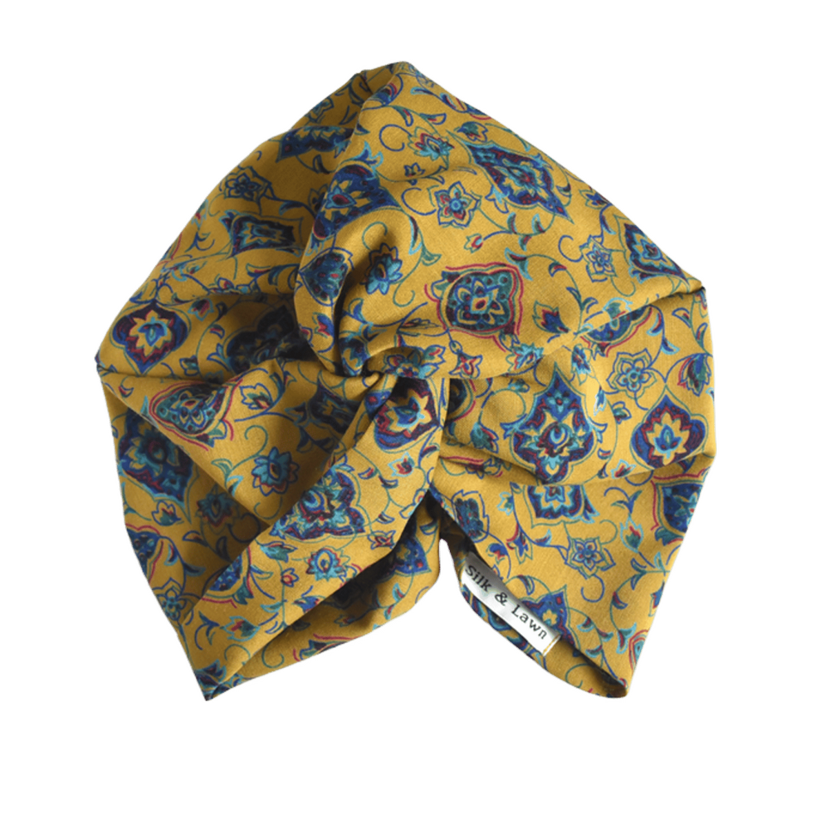 A mustard yellow fabric twisted headwrap or turban with a blue floral and geometric pattern, in varuna wool from hair accessory brand Silk & Lawn